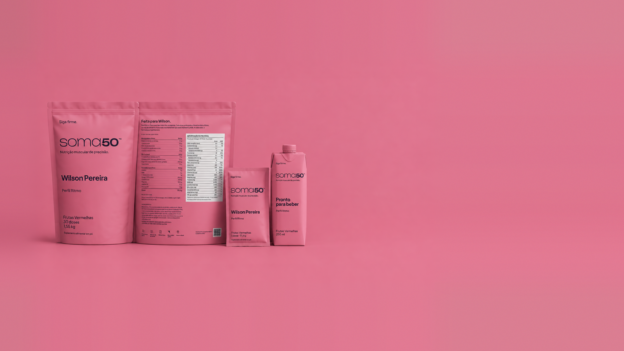 Kit SOMA50 com pouch grande, sachê individual e embalagem pronta para beber, sobre fundo rosa.